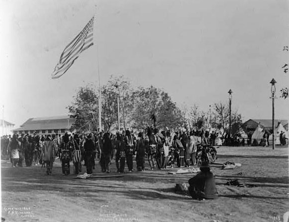 Photo: Cheyenne and Arapahoe people in circle around flagpole, at the Indian Congress of the Trans-Mississippi and International Exposition.