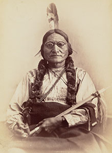 Photo: Sitting Bull, half-length portrait, facing front, holding peace pipe.